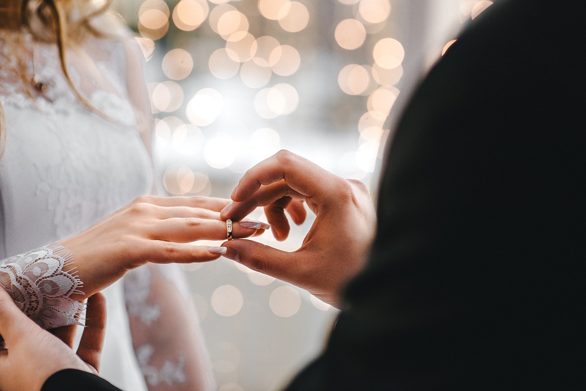 Man putting ring on bride's finger