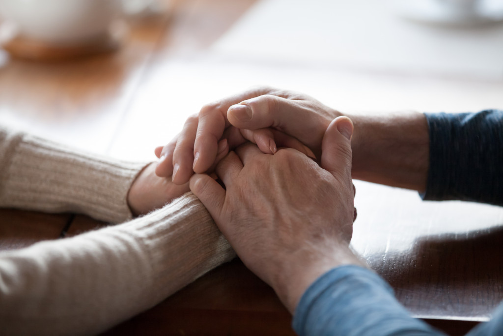 two pairs of hands holding together