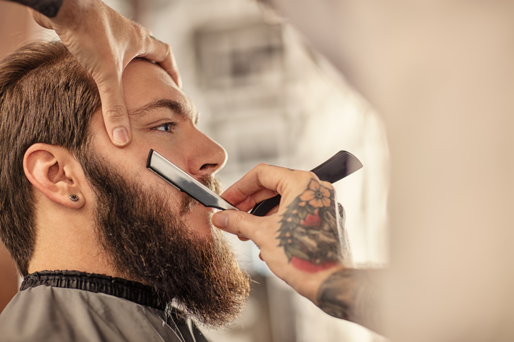 man having his beard shaved