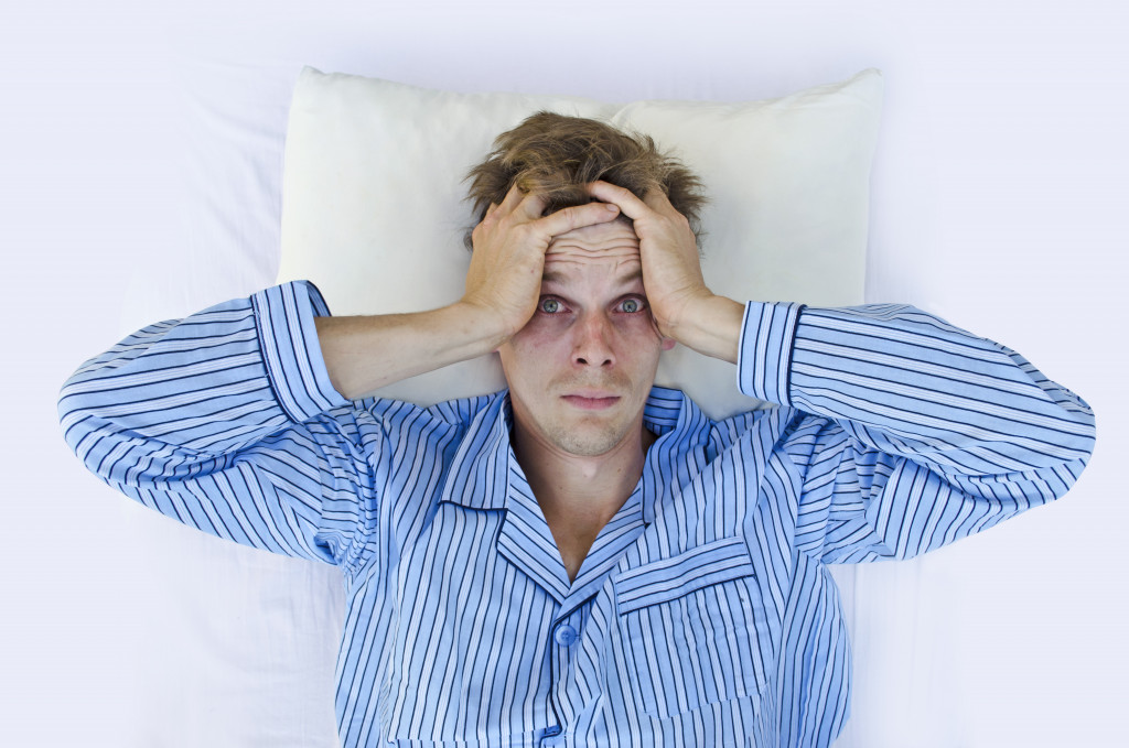 A man experiencing headache due to the lack of sleep