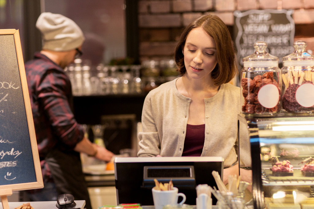 Woman or bartender at cafe or coffee shop counter