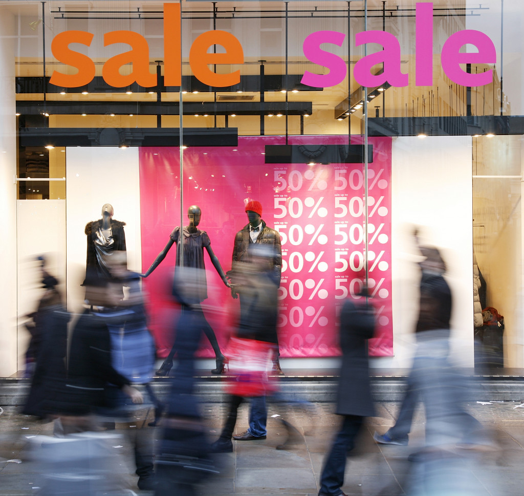 Sale signs on a clothing store in a busy city