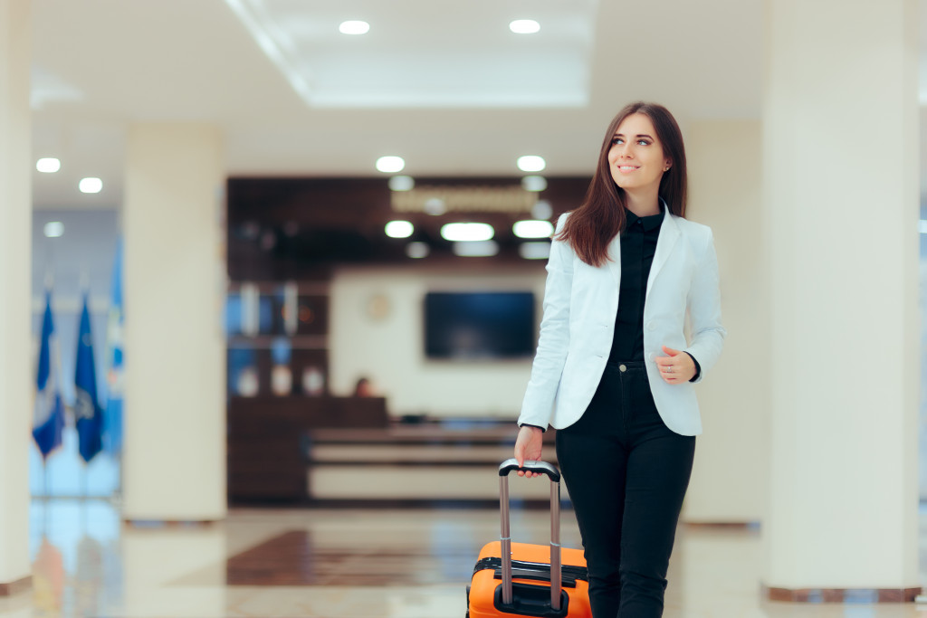 A woman wearing a white blazer while walking in an airport