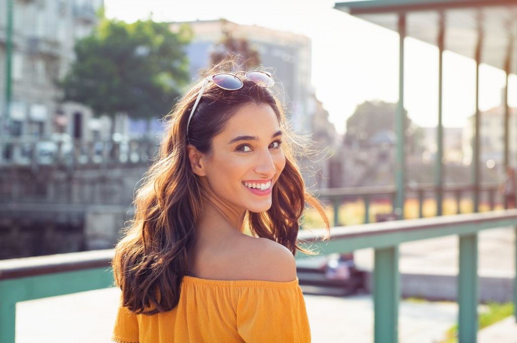 girl in yellow off-shoulder top smiling